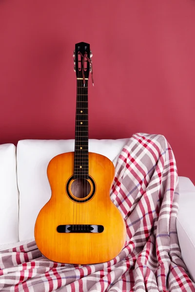 Gitarre auf einem großen Sofa — Stockfoto