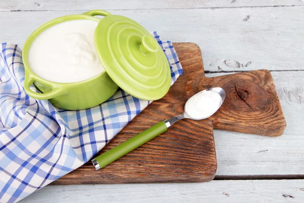 Green pan of cream on a napkin on cutting board — Stock Photo, Image