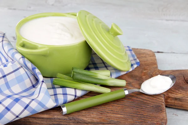 La cacerola verde de la crema en la servilleta en la tabla de cortar — Foto de Stock