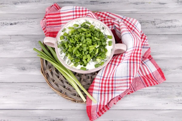 Rosa runda pannan av grädde med lök på en runda monter och mjuk servett på trä bakgrund — Stockfoto