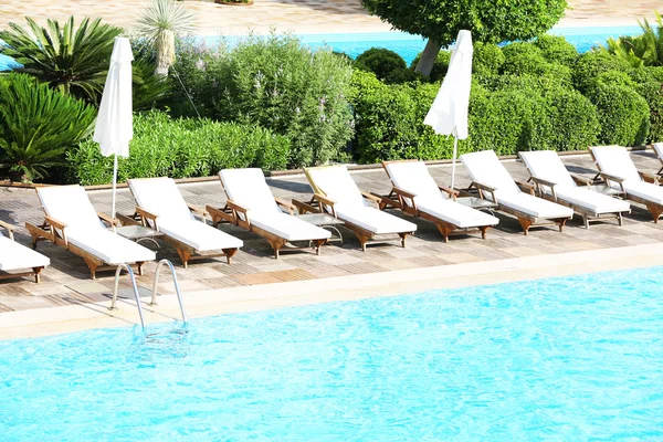 Chaises longues près de la piscine — Photo