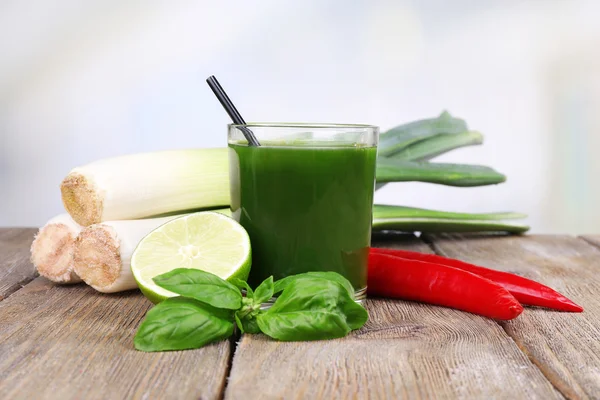 Jus de légumes frais avec oignon de printemps et poivre frais sur table en bois — Photo