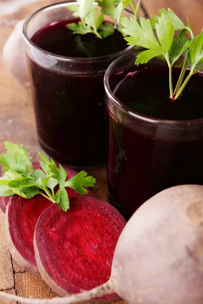 Glasses of fresh beet juice and vegetables on wooden background — Stock Photo, Image