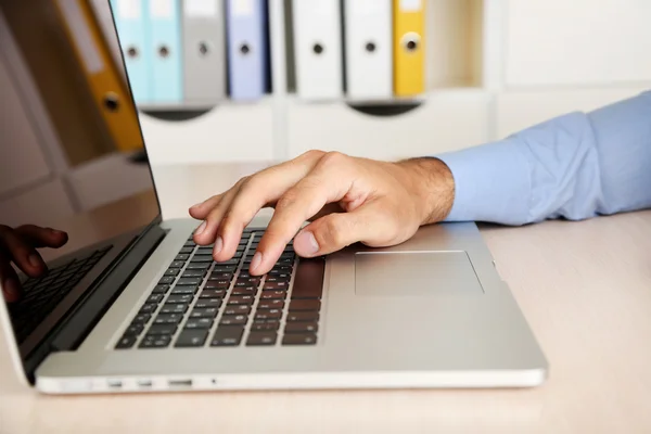 Homem trabalhando no laptop na mesa de madeira no fundo da pasta — Fotografia de Stock