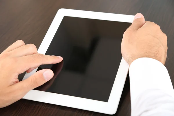 Man aan het werk op de Tablet PC op houten achtergrond close-up — Stockfoto