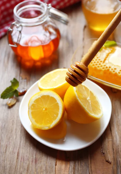Лимон и мед на деревянном столе — стоковое фото