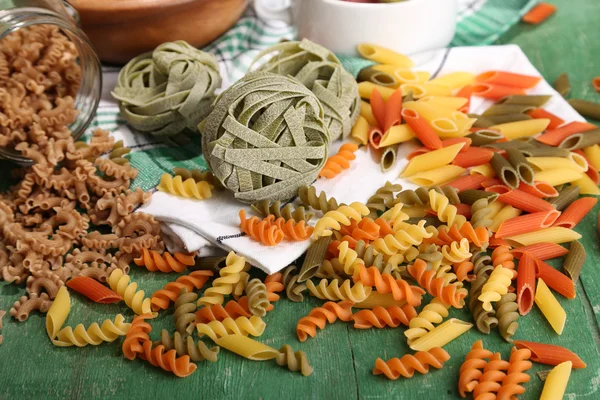 Verscheidenheid van kleurrijke pasta op houten achtergrond — Stockfoto