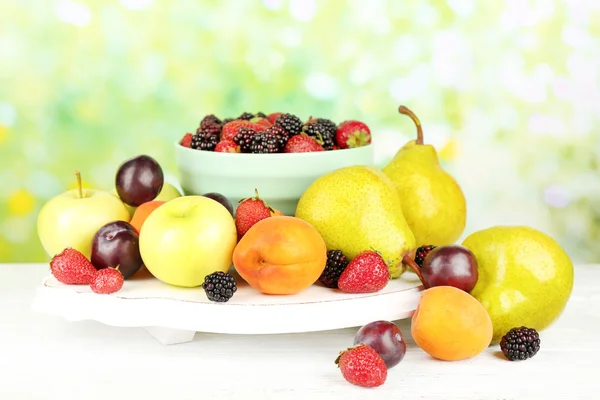 Ripe fruits and berries on table on bright background — Stock Photo, Image