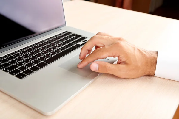 Man working on laptop on wooden table closeup — Stock Photo, Image