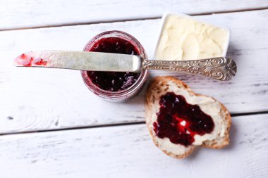taze ekmek ile ev yapımı tereyağı ve blackcurrant jam hafif ahşap arka plan üzerinde