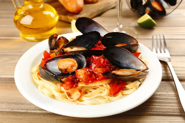 Macarrão saboroso com mexilhões na mesa, close-up — Fotografia de Stock