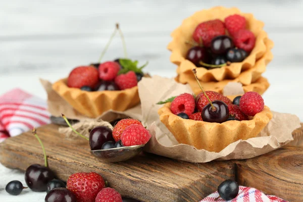 Вкусные пирожные с ягодами на деревянном столе — стоковое фото