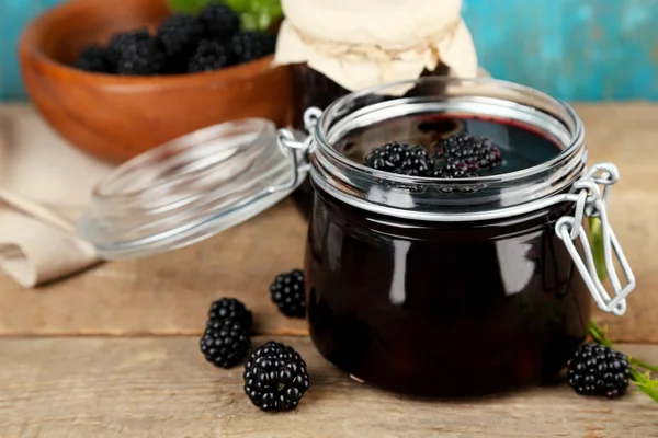 Smakelijke blackberry jam en verse bessen, op houten tafel — Stockfoto