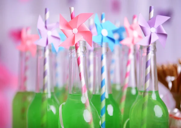 Bottles of drink with straw on decorative background — Stock Photo, Image