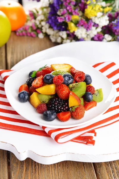 Deliciosa ensalada de frutas en plato en primer plano de mesa —  Fotos de Stock