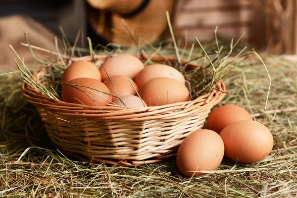 Huevos en canasta de mimbre en primer plano de la mesa — Foto de Stock