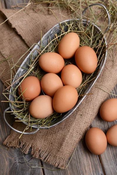 Ägg i rotting korg på tabell närbild — Stockfoto