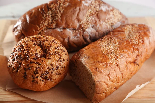 Ahşap zemin üzerinde kesme tahtası üzerinde taze pişmiş ekmek — Stok fotoğraf