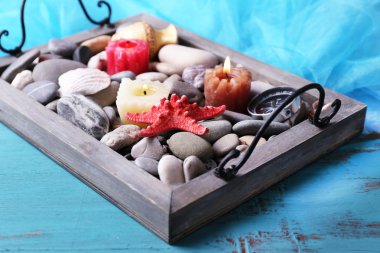 vintage tepsi Denizi çakıl taşları ile deniz yıldızı ve deniz kabukları ahşap zemin üzerine mum