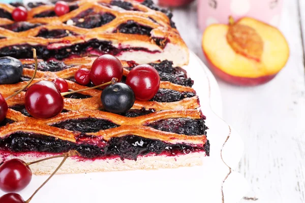 Sweet berries and berry tart on table close-up — Stock Photo, Image