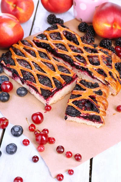Sweet berries and berry tart on table close-up — Stock Photo, Image