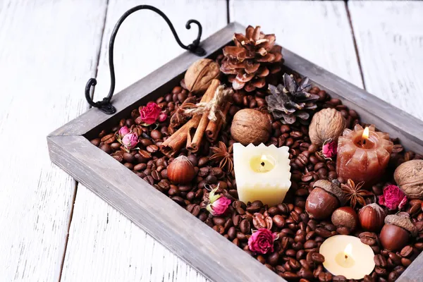 Kaarsen op vintage dienblad met korrels van koffie en kruiden, bultjes op kleur houten achtergrond — Stockfoto