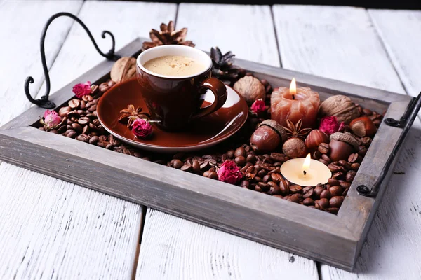 Candles on vintage tray with coffee grains and spices, cup of tea on color wooden background — Stock Photo, Image