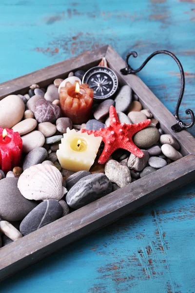 Velas en bandeja vintage con guijarros de mar, estrellas de mar y conchas de mar sobre fondo de madera —  Fotos de Stock