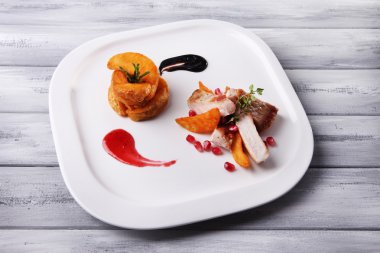 kızarmış patates parçaları ve plaka renk ahşap zemin üzerine nar taneleri ile ızgara et