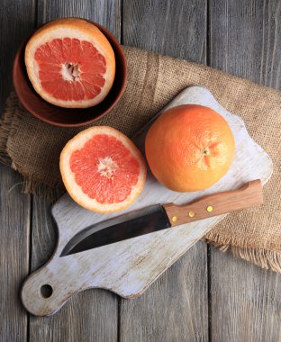 Olgun greyfurt ve ahşap zemin üzerinde kesme tahtası üzerinde bıçak