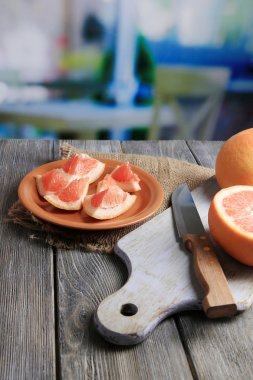 Olgun greyfurt ve parlak zemin üzerine ahşap masa üzerinde kesme tahtası üzerinde bıçak