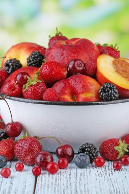 şeftali ve doğal zemin üzerine masada kase çilek