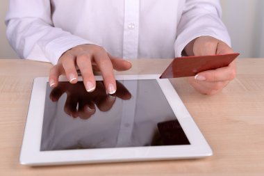kredi kartı ve bilgisayar tablet masanın üstünde tutan eller yakın çekim