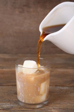 cam ahşap zemin üzerine sütlü buz küpleri ile buzlu kahve