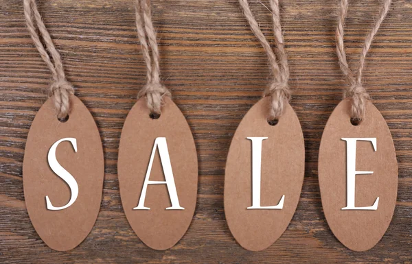 Sale tags on wooden background — Stock Photo, Image
