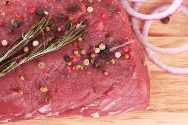 Rå nötkött med kryddor på trä bakgrund — Stockfoto