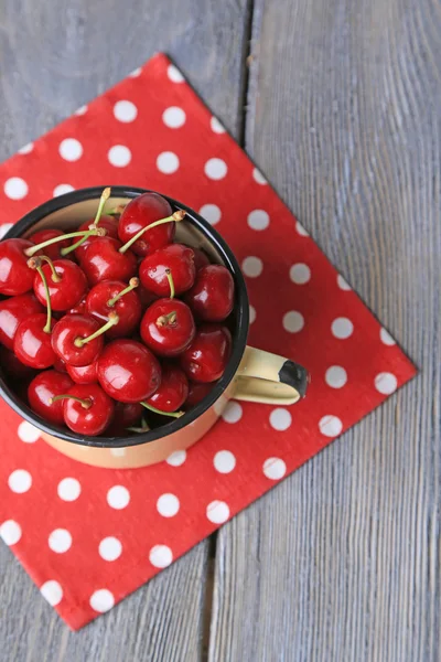 Sweet cherries in mug on wooden background — Stock Photo, Image