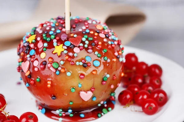 甜甜的焦糖苹果木制的桌子上的浆果，棒上 — 图库照片