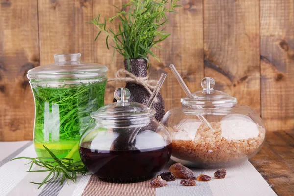 Estragon drink with lemon and brown sugar on tablecloth on wooden background — Stock Photo, Image