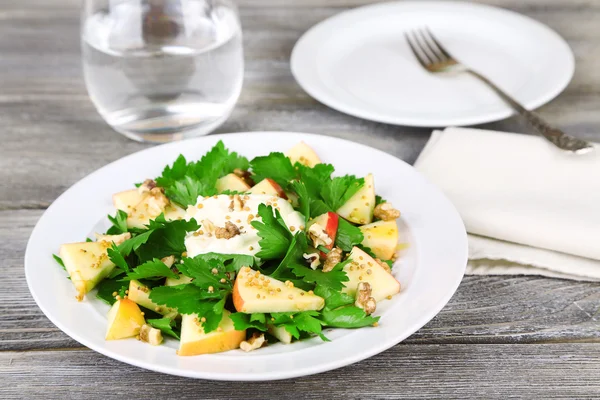 Green salad with apples, walnuts and cheese on wooden background — Stock Photo, Image