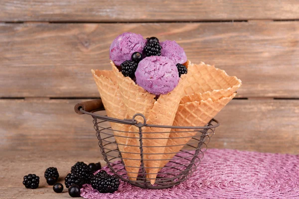 Sabroso helado con bayas en cono de gofre sobre fondo de madera marrón —  Fotos de Stock