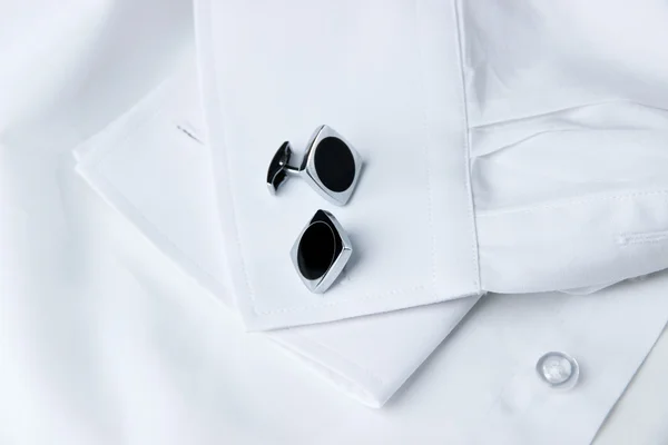 Een paar van manchetknopen op een mouw van het witte shirt en een cravat in de buurt van het — Stockfoto