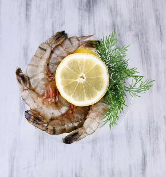 Martini copa de gambas frescas sabrosas con limón y eneldo sobre fondo de madera gris — Foto de Stock