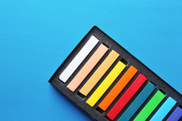 Kleurrijke krijt pastels in vak op een houten achtergrond kleur — Stockfoto