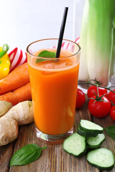 Glass of fresh carrot juice and vegetables on wooden table — Stock Photo, Image