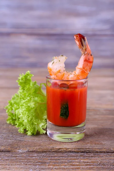 Crevettes fraîches bouillies avec laitue dans un verre avec sauce tomate sur fond de bois — Photo