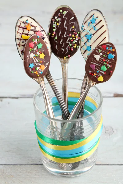 Spoons with tasty chocolate for party on old wooden table — Stock Photo, Image