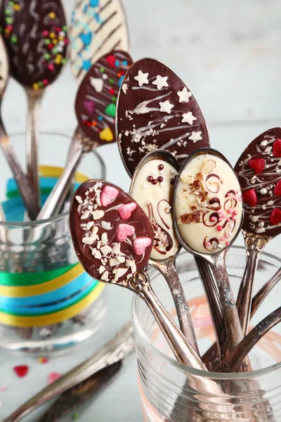 Colheres com chocolate saboroso para festa na velha mesa de madeira — Fotografia de Stock