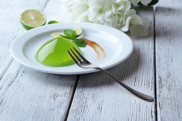 Groene gelei met munt verlaat op houten achtergrond — Stockfoto