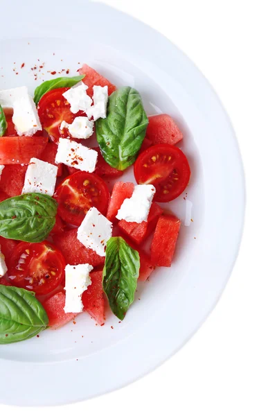 Salad with watermelon, feta and basil leaves on plate, isolated on white — Stock Photo, Image
